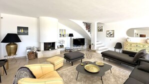 A modern living room with a fireplace, a sofa set, a coffee table, and a TV.
