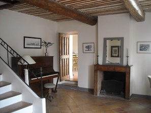 A staircase leading to a landing with a piano and a fireplace. - Provencal farmhouse from the 19th century with swimming pool, charming house (Aix-En-Provence)