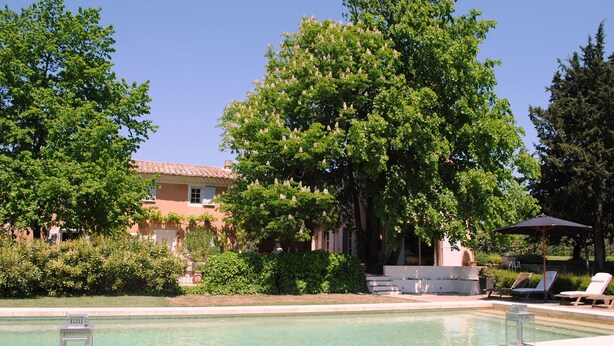 A pool area with lounge chairs, a sun umbrella, and a building with a tiled roof. - Provencal farmhouse from the 19th century with swimming pool, charming house (Aix-En-Provence)