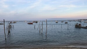 A beach with boats anchored in the water and a sandy shore.