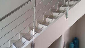 Una escalera moderna con barandillas de metal y un interior blanco.