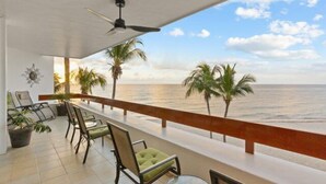 A balcony with a view of the ocean, equipped with chairs and a table. - Corner Unit in the Building That (San Miguel)