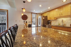 A kitchen with granite countertops, wooden cabinets, and stainless steel appliances.