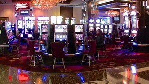 Ein Casino mit Spielautomaten und roten Sesseln.