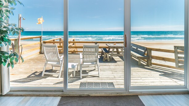 A beachside deck with wooden chairs and a table, overlooking the ocean. - Mamaw's Spot | Oceanfront + Pet Friendly! (Topsail Beach)