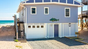 A two-story beach house with a blue exterior, a front door, and a small porch. - Mamaw's Spot | Oceanfront + Pet Friendly! (Topsail Beach)