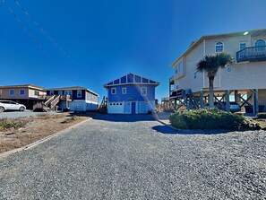 A coastal residential area with a blue house, a white car, and a building with a balcony. - Mamaw's Spot | Oceanfront + Pet Friendly! (Topsail Beach)