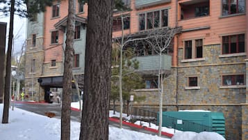 A multi-story building with a stone facade and red-framed windows.