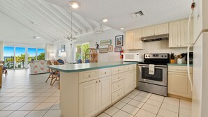 A spacious kitchen with a large island, white cabinetry, and stainless steel appliances.