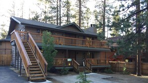 A two-story lodge with a wooden exterior, a front porch, and a staircase leading to the upper level. - Walking distance to Snow Summit! (Big Bear Lake)