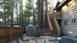 A patio with outdoor furniture, a wooden deck, and a staircase leading to a house. - Walking distance to Snow Summit! (Big Bear Lake)