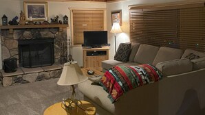 A cozy living room with a fireplace, a television, and a comfortable sofa. - Walking distance to Snow Summit! (Big Bear Lake)