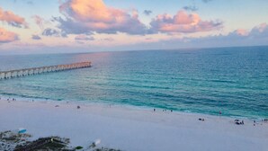 A beach with a pier extending into the sea, sandy shore, and clear sky. - 
Gorgeous Beachfront.  Complimentary Beach Service and High Capacity Ice Maker! (Navarre Beach)