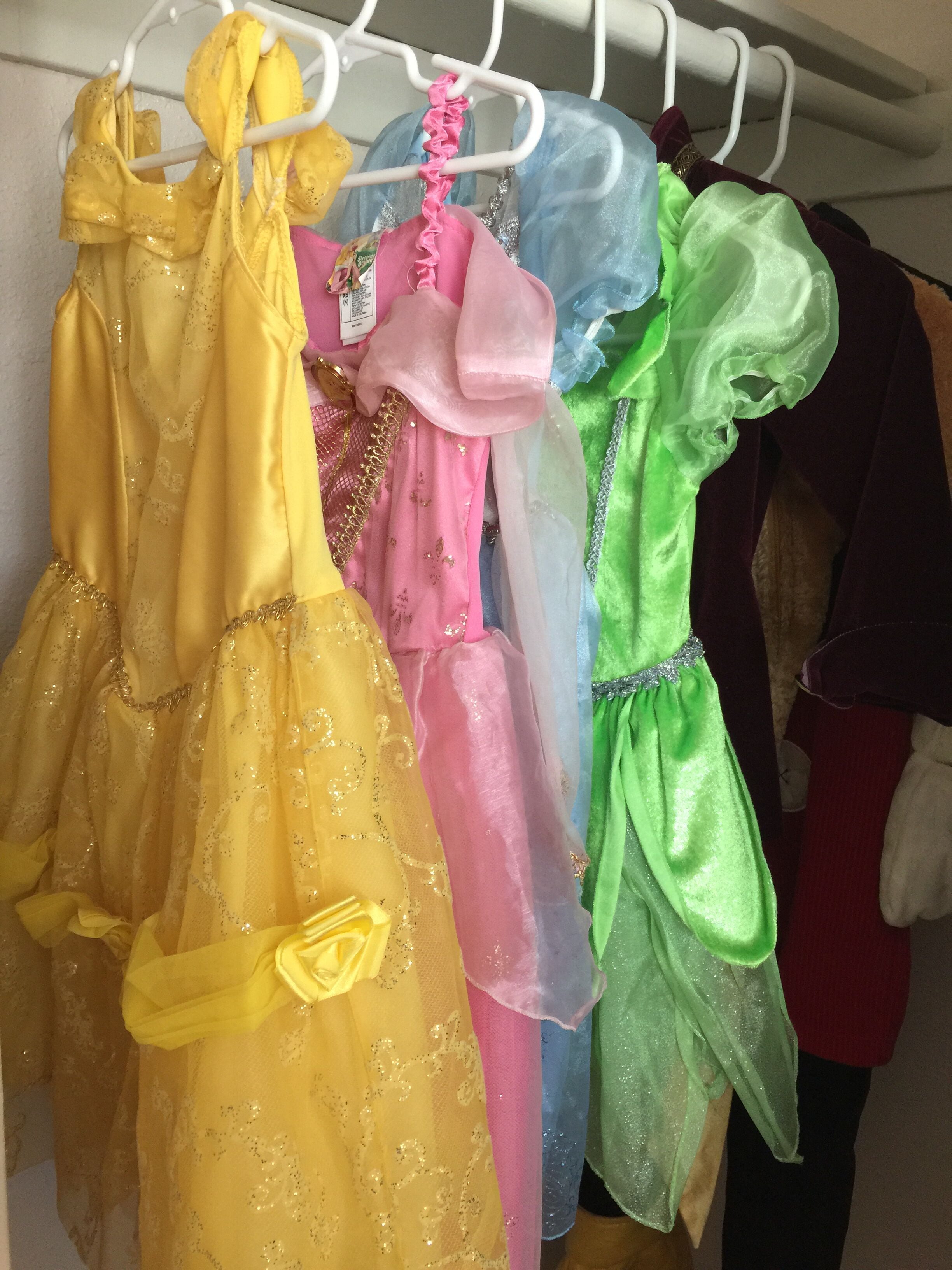 A rack of colorful dresses hanging on a white metal rack.
