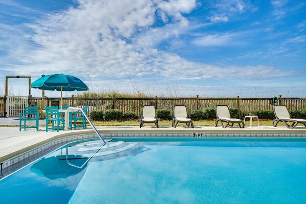 A swimming pool with lounge chairs and an umbrella. - Beachfront | 1st Floor Condo | Mariner West | Pool (Panama City Beach)