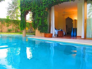 A swimming pool with a covered outdoor seating area, a table, and chairs. - Full-privacy in charming 3-bdr house with heated pool, garden & jet tub (La Cruz de Huanacaxtle)
