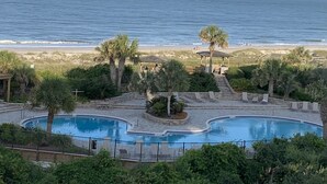 Zona de piscina con vista a la playa y al océano.
