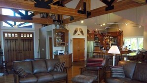 A spacious living room with leather sofas, a coffee table, and a dining area with wooden furniture. - Riverfront Lodge great setting, walk to downtown! (Bend)