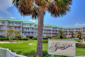A hotel with a green roof, multiple balconies, and a sign reading "St. Simons Grand".