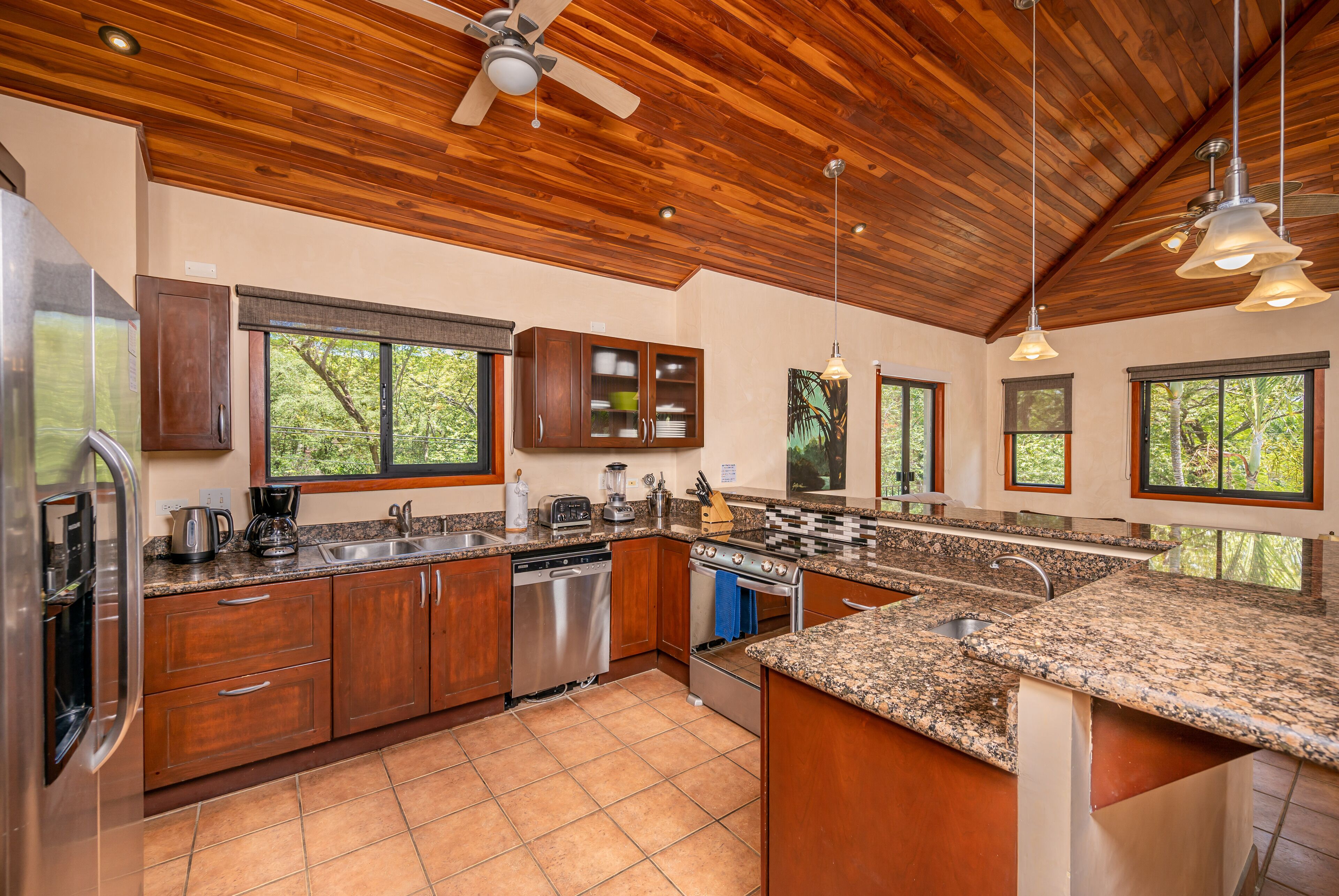 A modern kitchen with wooden cabinets, granite countertops, and a large island.