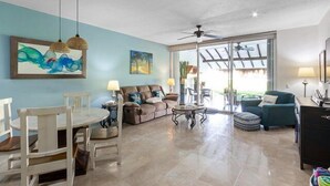 A spacious living area with a dining table, sofas, and a ceiling fan. - 1-Bedroom Unit With Convenient Access to the Pool and Beach (Cozumel)