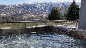 Un jacuzzi con vistas a montañas nevadas.