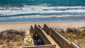 A wooden boardwalk leading to a beach with waves crashing onto the shore. - The Salty Spot | Family Favorite Oceanfront Retreat w/Beach Access (Surf City)