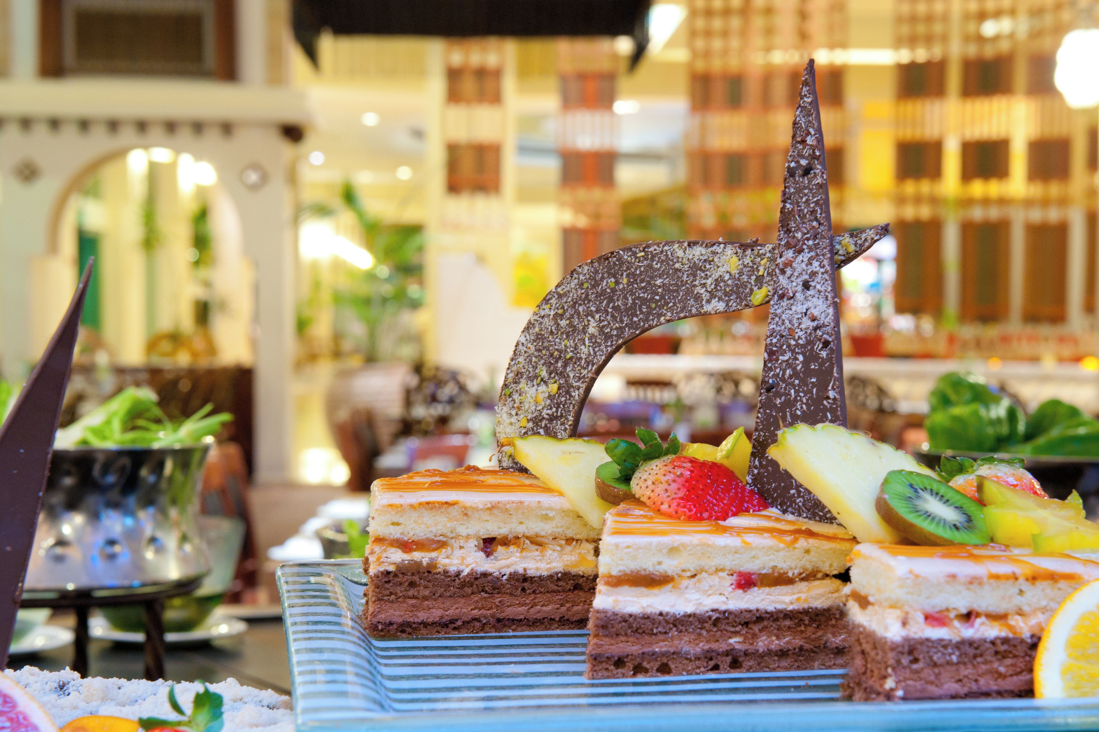 Eine Dessert-Auslage mit mehreren Tortenschichten und Früchten als Belag.