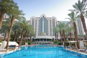 A hotel with a large pool surrounded by palm trees and lounge chairs. - Herods Palace Hotels & Spa Eilat (Eilat)