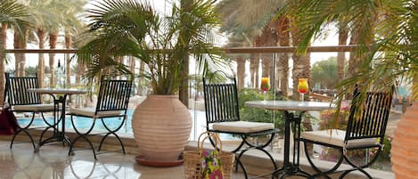 A poolside area with seating and a large vase.