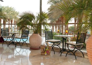 A poolside area with seating and a large vase. - Herods Palace Hotels & Spa Eilat (Eilat)