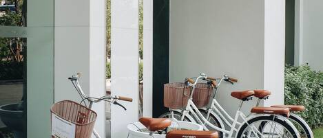 Une rangée de vélos est garée contre la façade d’un immeuble.