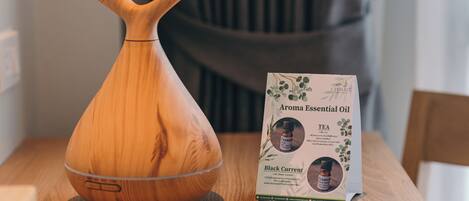 Un difusor de madera y un paquete de aceite esencial Aroma sobre una mesa de madera.