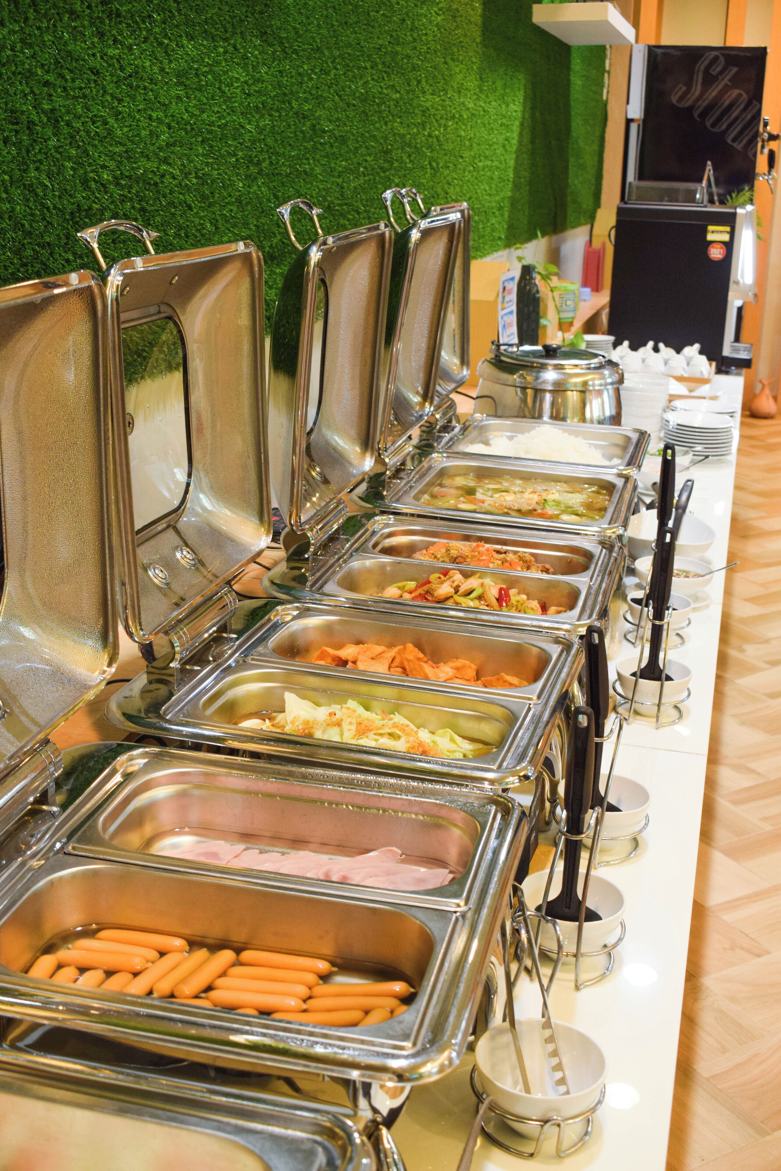 A buffet with various food options, including hot dogs, salads, and other dishes.
