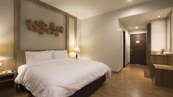 Ein modernes Hotelzimmer mit einem großen Bett, einem Holzkopfschild, einer Wanduhr und Holzboden.