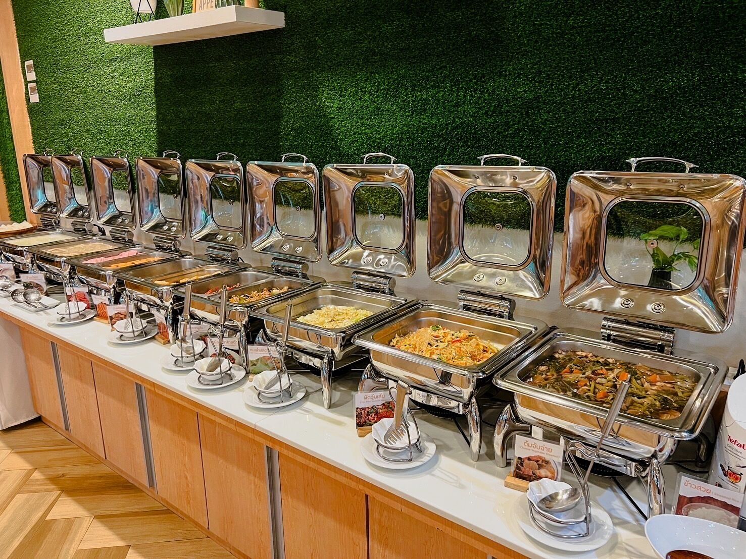 Ein Buffet mit mehreren Selbstbedienungsstationen, an denen verschiedene Gerichte angeboten werden.