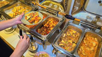 Un bufé con diversos platos, incluyendo mariscos y verduras salteadas.