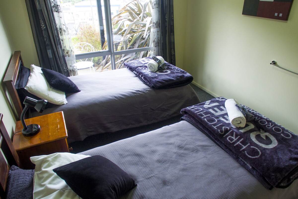 A twin room with two beds, a desk, and a chair.