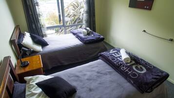 A twin room with two beds, a desk, and a chair.