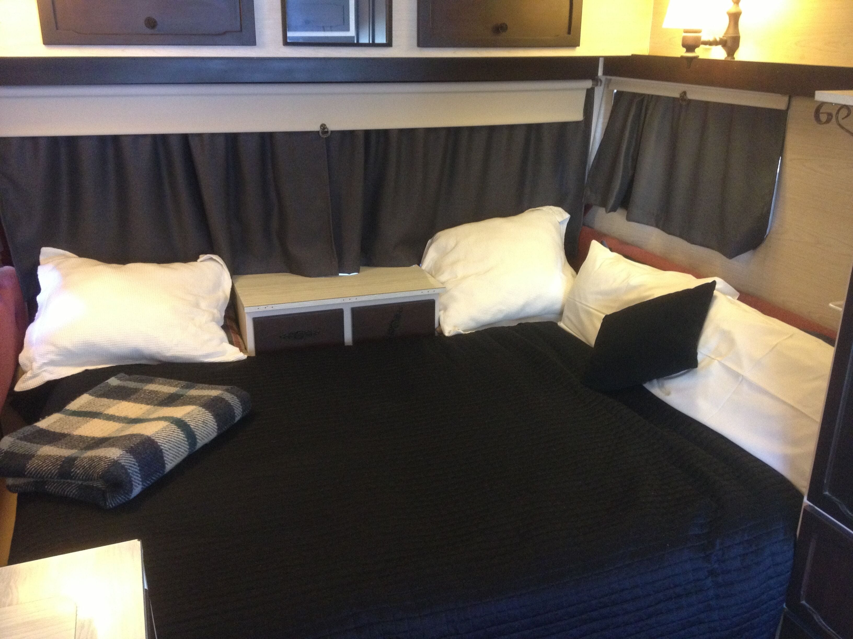 Un lit compact avec une tête de lit, une table de chevet et un oreiller.