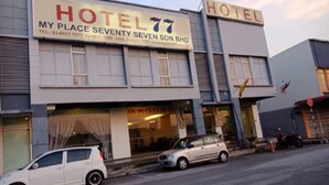 Un hotel llamado 'Hotel 77' con un letrero que muestra información de contacto.
