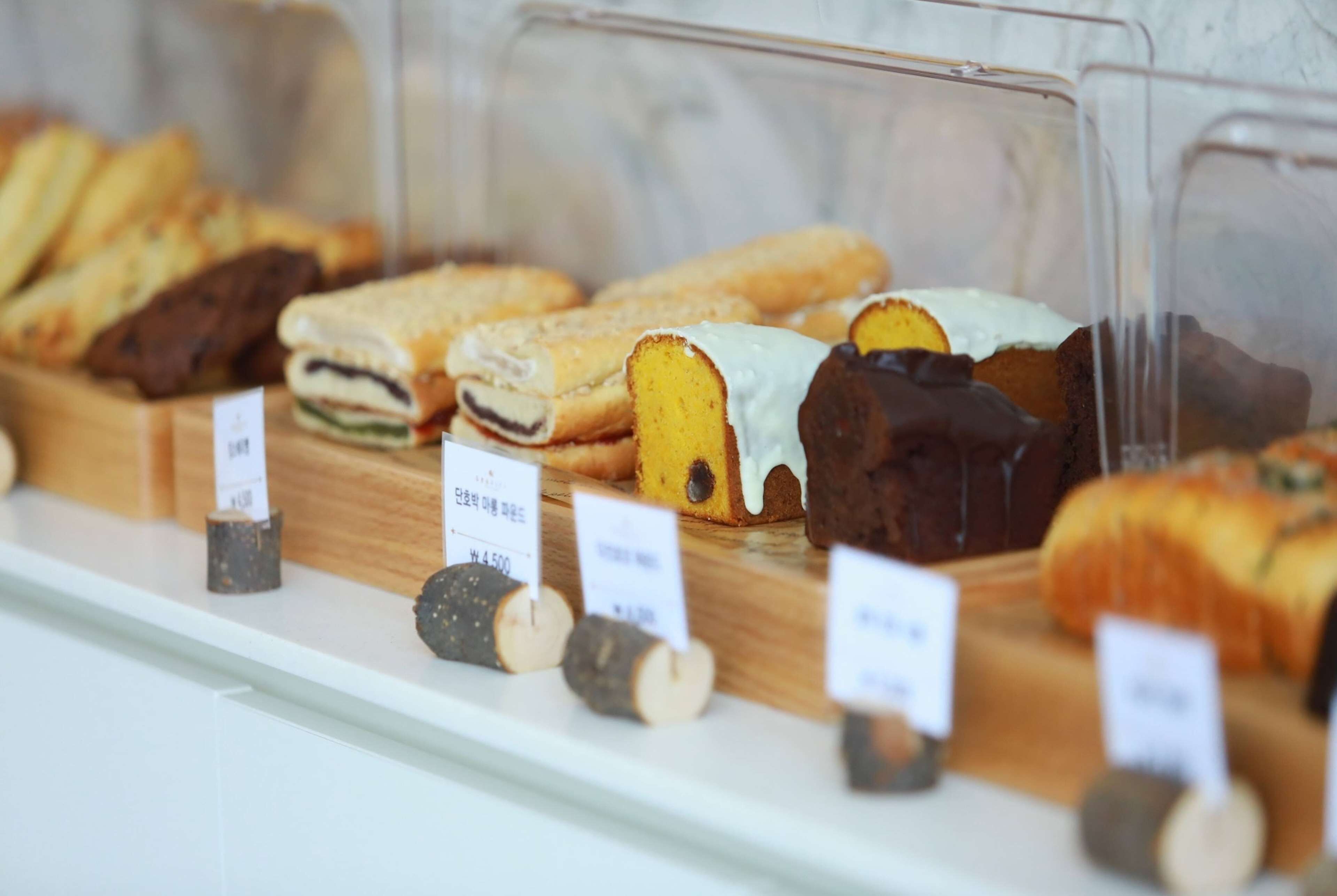 A display case of various pastries and desserts with price tags.