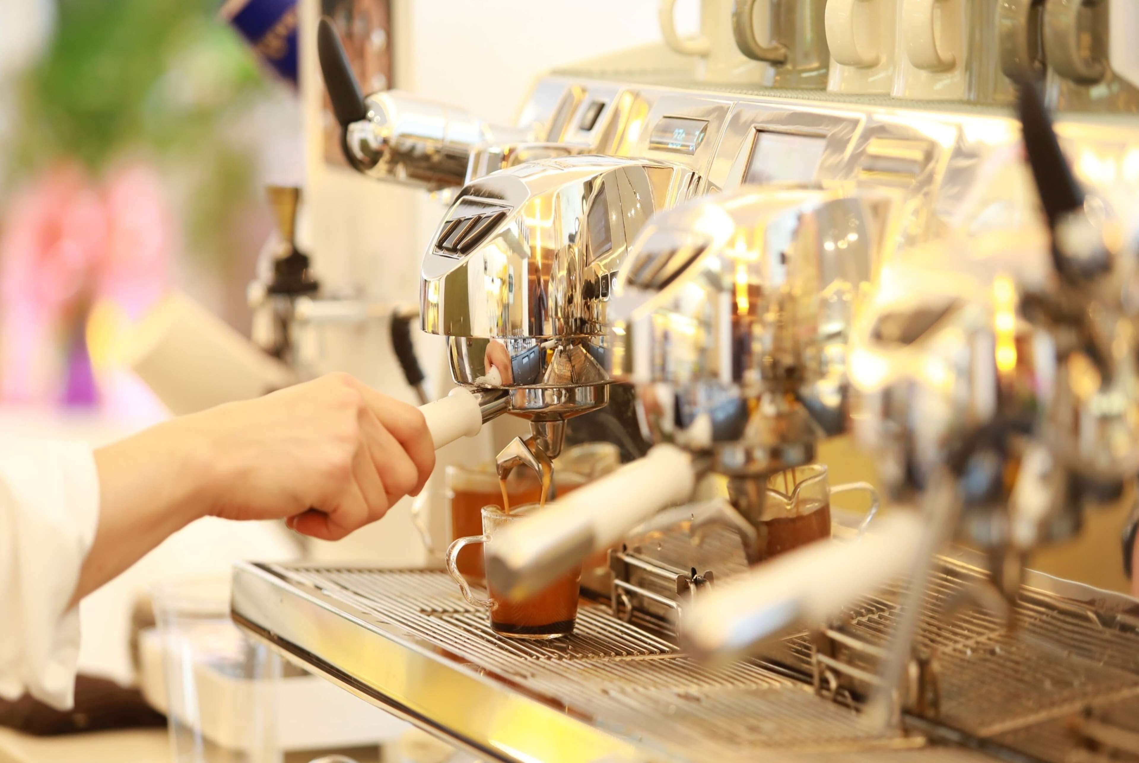 Une personne utilise une machine à expresso pour préparer une tasse de café.