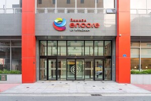 Un edificio con entrada de vidrio, un logotipo con un remolino colorido y las palabras "Ramada encore by Wyndham" sobre la entrada.