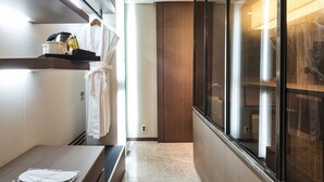 Un baño moderno con ducha, tocador con espejo y perchero para toallas.