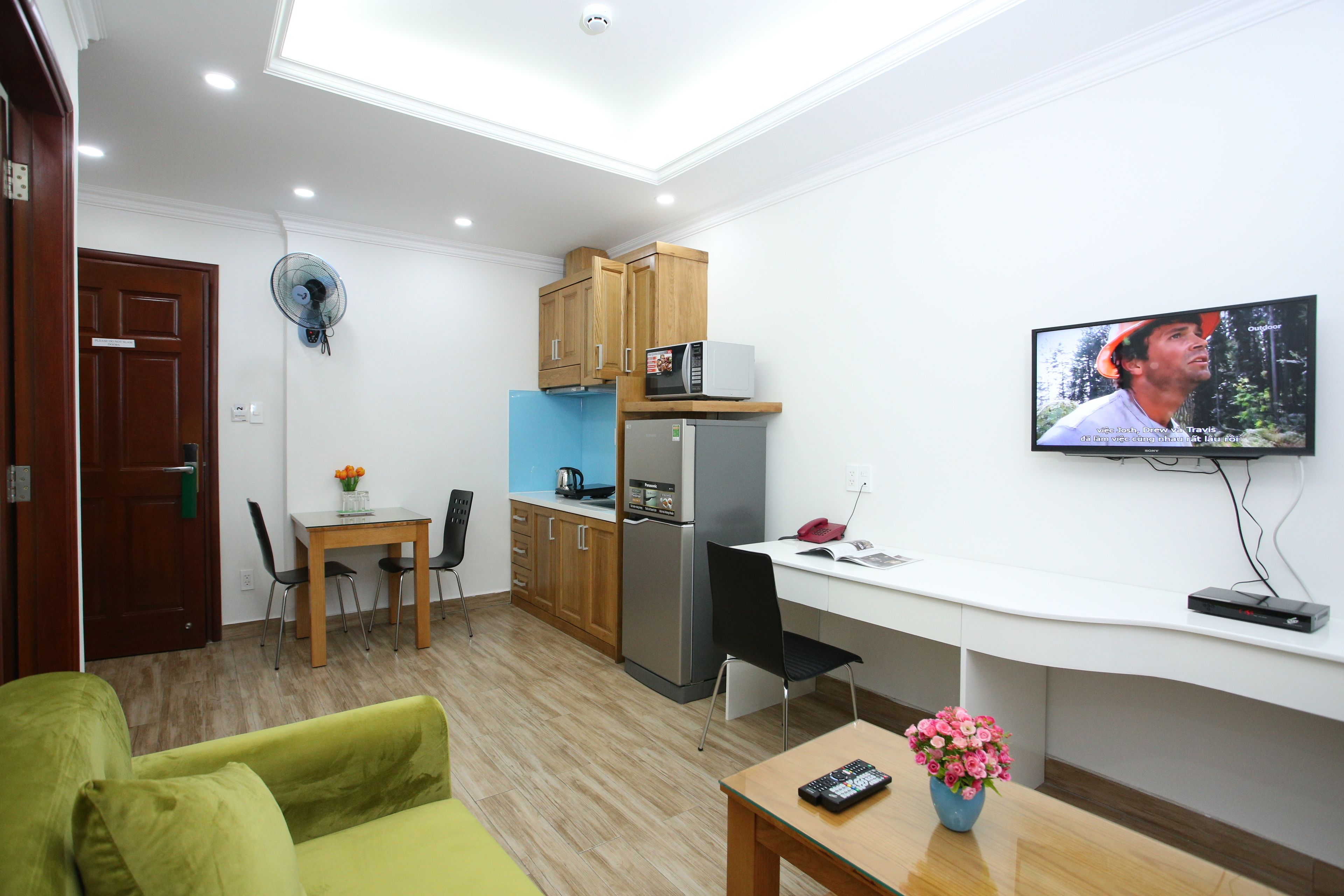 Un espacio habitable compacto con kitchenette, comedor y zona de estar.