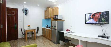 Un espacio habitable compacto con kitchenette, comedor y zona de estar.