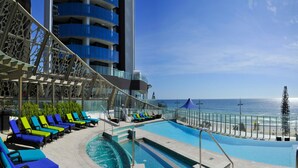 A poolside area with lounge chairs and a pool, overlooking the ocean. - Esplanade (Soul) - Apartment Stay Private (Surfers Paradise)