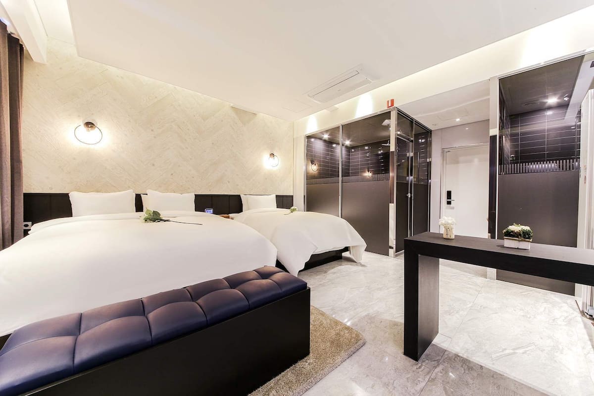 Ein modernes Hotelzimmer mit einem großen Bett, einem Nachttisch und einem Spiegel.