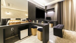 A modern kitchen with a built-in island, a flat-screen TV, and a seating area with a cushioned bench. - HOTEL OSCAR (Daegu)